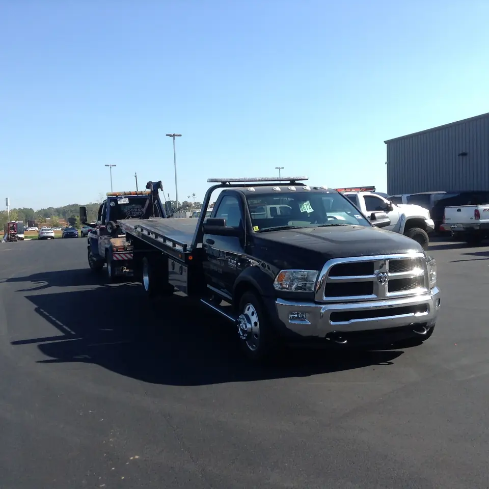 Joey's black Ram rollback flatbed parked in a sunny lot